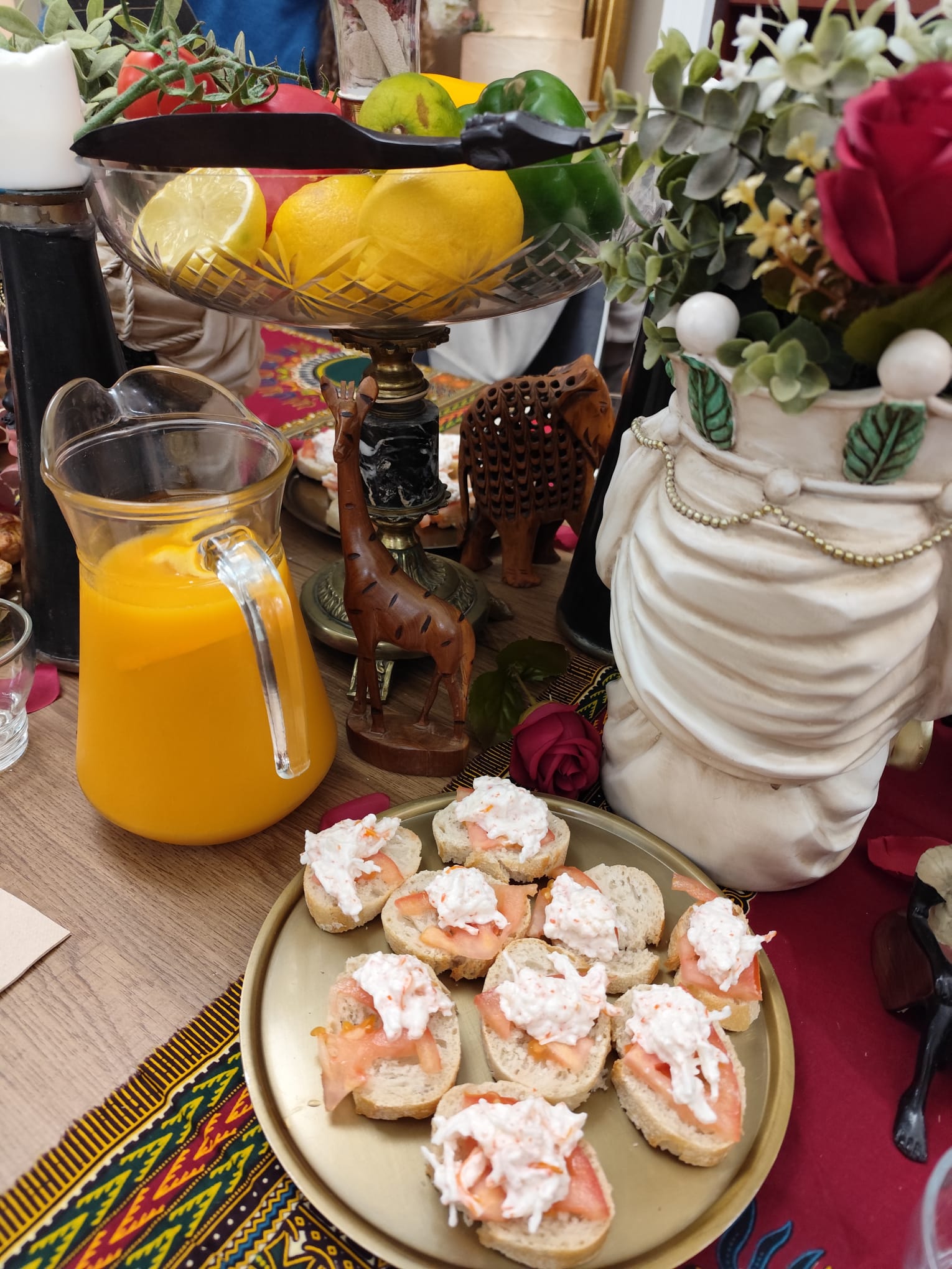 Merienda temática con frutero de cristal, tallas de madera y canapés