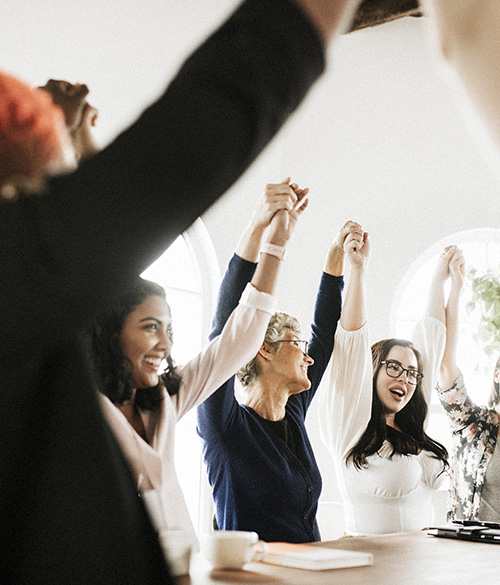 Mujeres cogidas de la mano triunfales